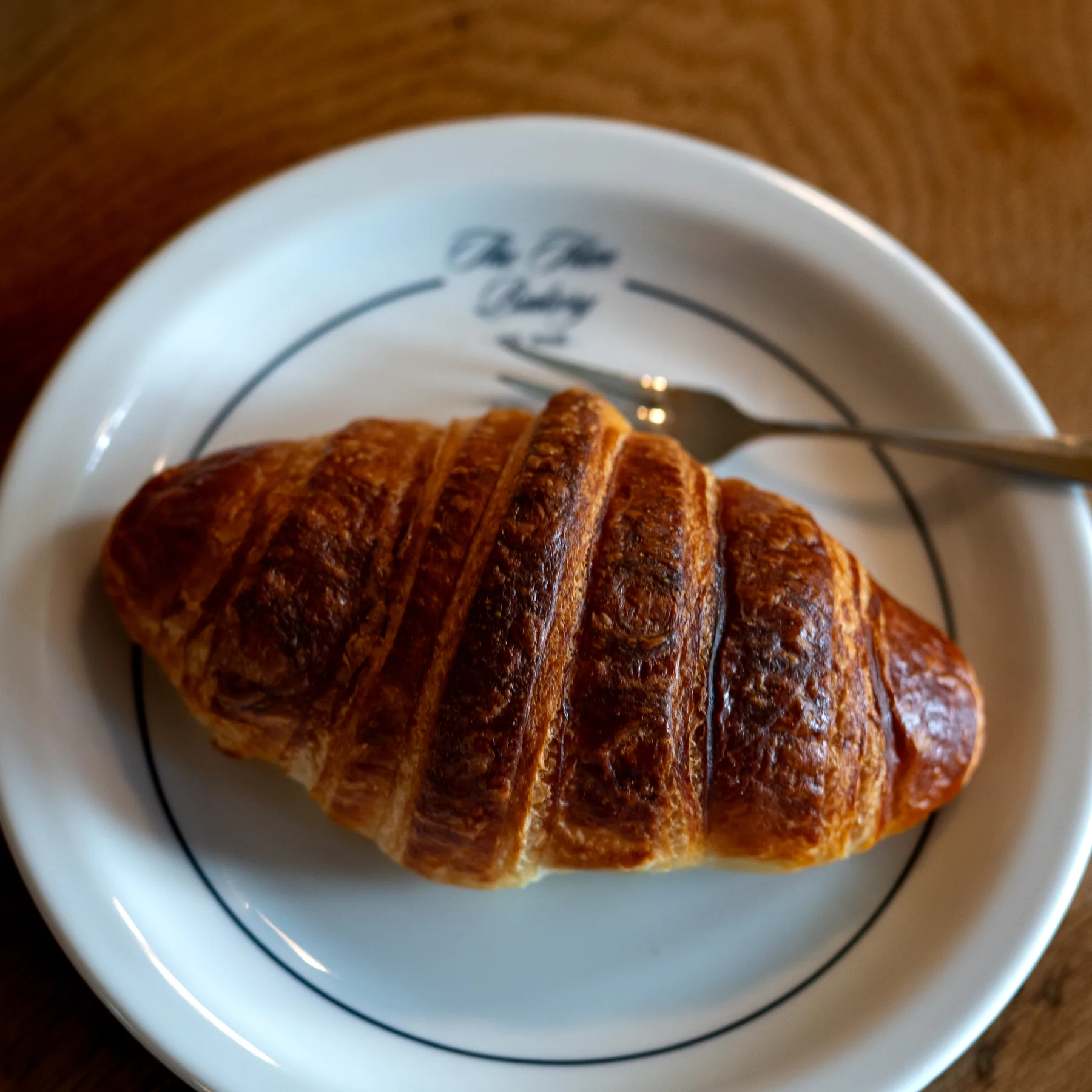 Maślany croissant na talerzu The Hive